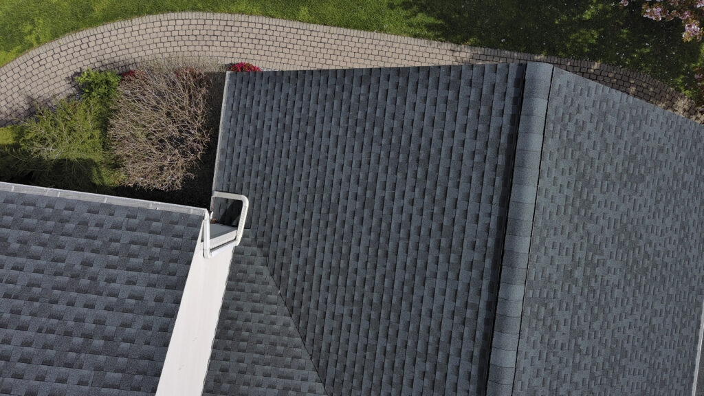 Close-up aerial view of a completed Highland roof replacement with clean asphalt shingle installation